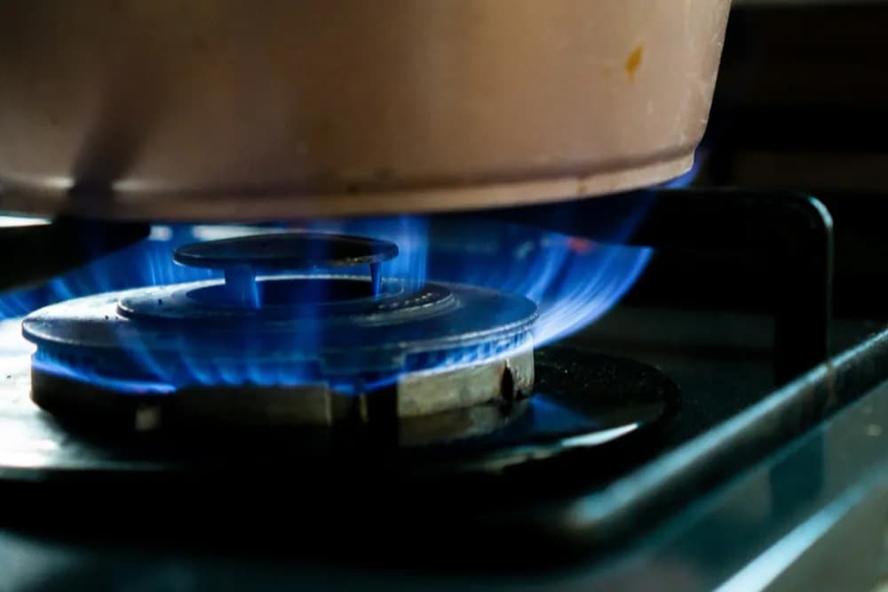Casserole posée sur un foyer allumé, couronne de flamme visible