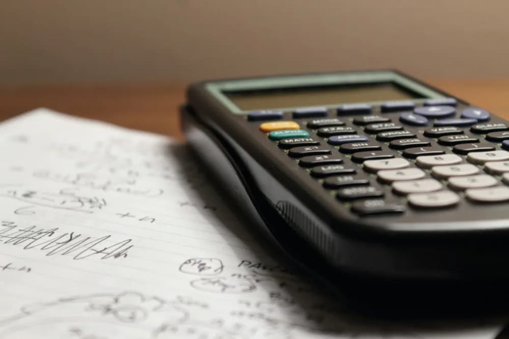 Calculatrice posée sur une feuille manuscrite