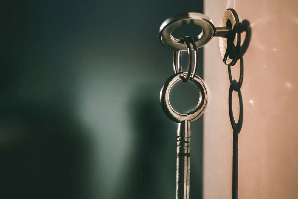 Deux clés suspendues côte à côte devant un fond sombre
