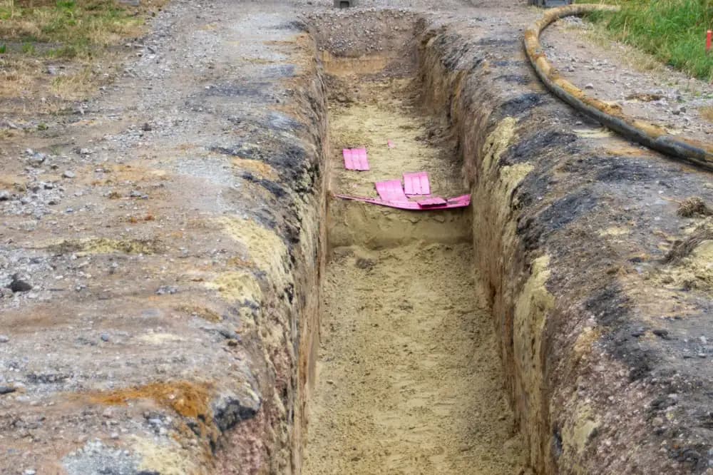 Tranchée de chantier balisée par une barrière et des feux